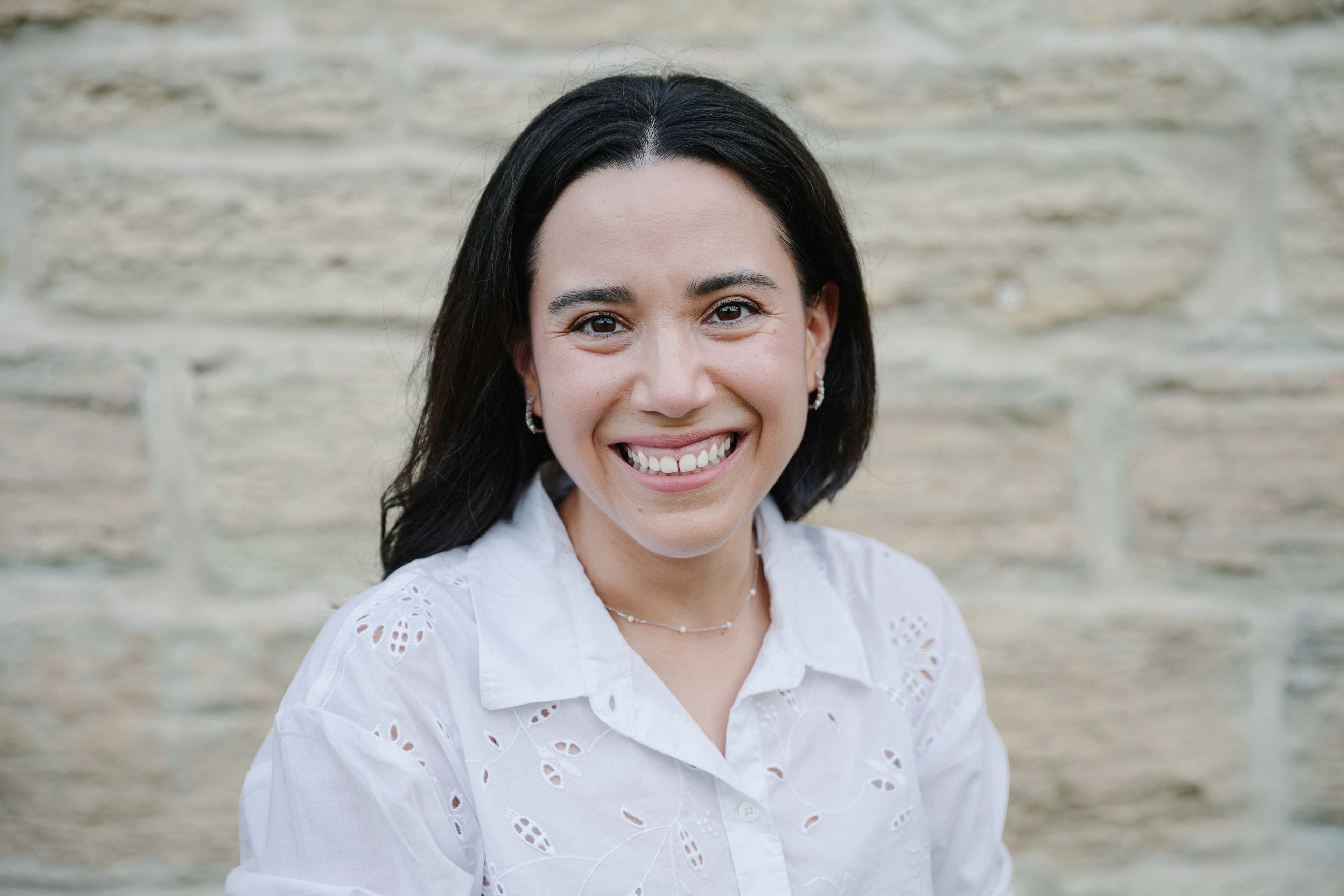 Maria Escamilla, DNP, CNM, smiling in front of a limestone wall